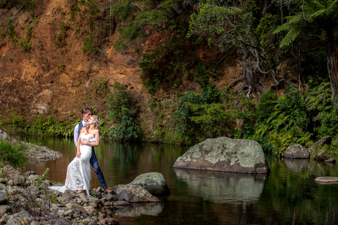Bride and Groom embrace by the river